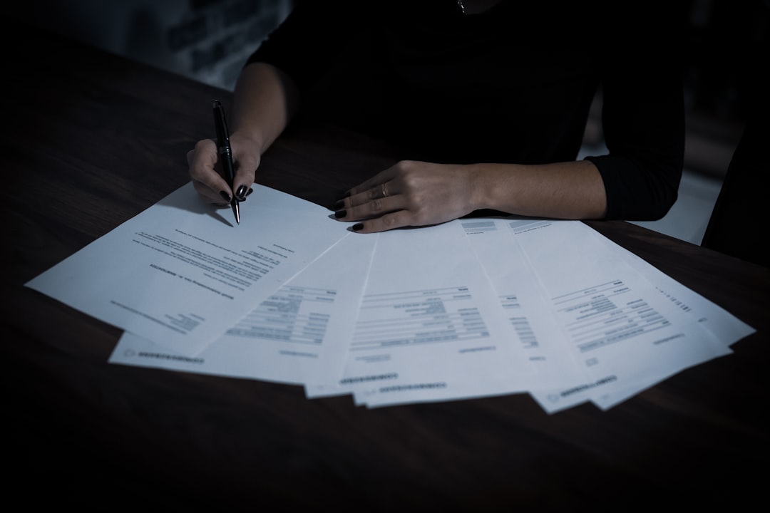 A lady signing a contract with a ballpoint pen.